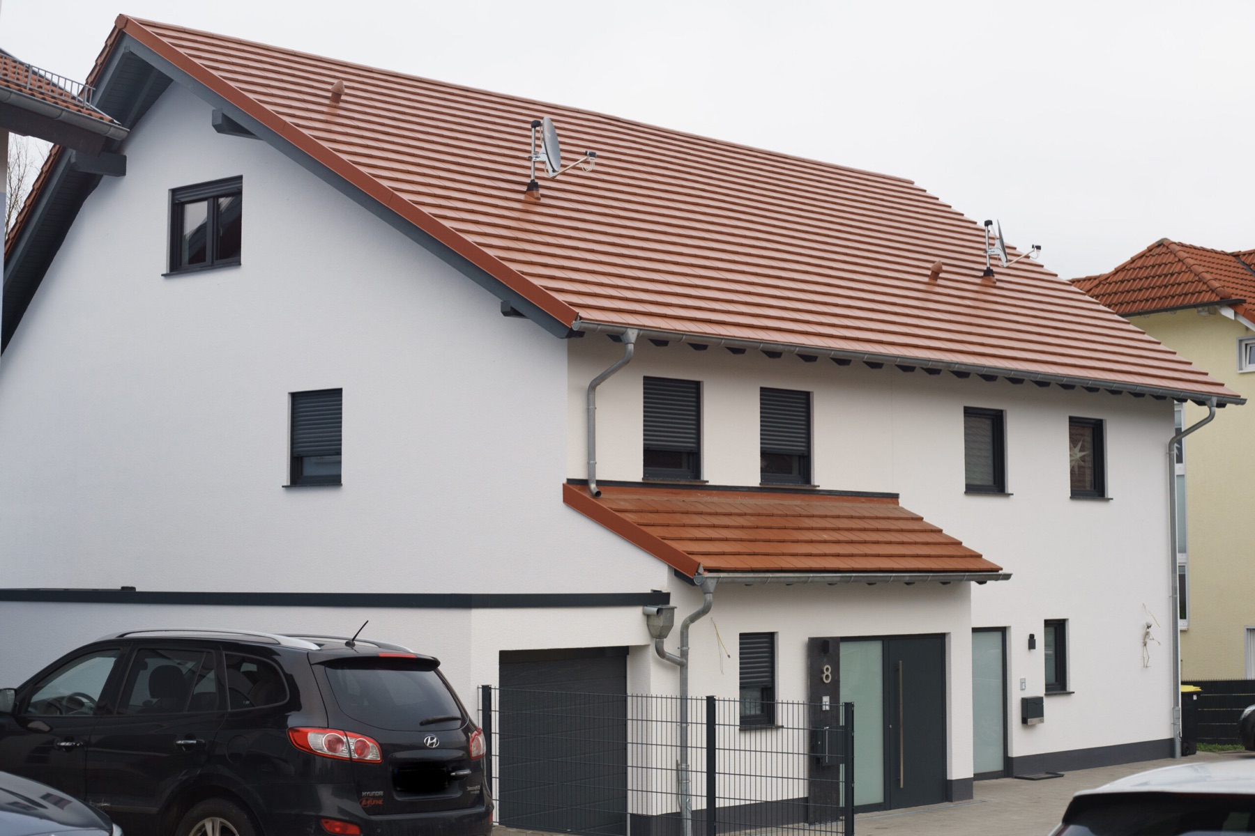 Fertiggestelltes Wohnhaus mit heller Fassade und rotem Ziegeldach